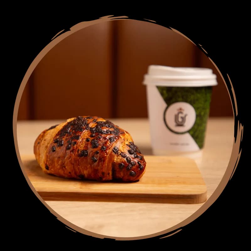 Chocolate croissant with a Grande Cafe cup
